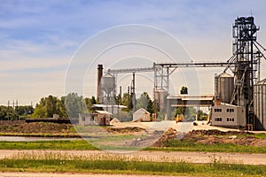 Production yard with lift and machinery of modern silo in countryside