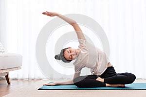 Productive activity concept a female young adult wearing a white t-shirt practicing the flexibility of her body by doing mat