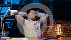 Productive Korean businessman Asian man Chinese business worker leaning back finishing work on laptop close computer