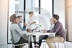 Productive planning in progress. a businesswoman giving a presentation to her colleagues in a modern office.