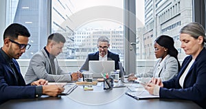 Productive teams always get things done on time. a group of businesspeople having a meeting in a boardroom.