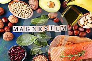 Products containing magnesium: bananas, almonds, avocado, nuts and spinach and eggs on background