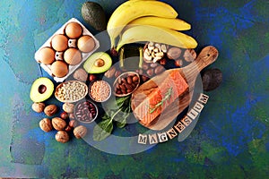 Products containing magnesium: bananas, almonds, avocado, nuts and spinach and eggs on background