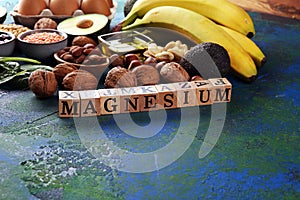 Products containing magnesium: bananas, almonds, avocado, nuts and spinach and eggs on background