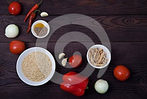 Products rice, vegetables, spices and soy meat for cooking jollof rice on a brown wooden background. National cuisine of Africa.