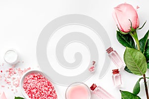 Products for skincare based on rose oil. Cream, lotion, spa salt on white background top view copyspace