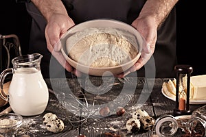 Products, yeast dough in bowl on black
