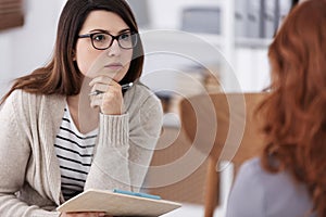 Profesional counselor with notepad and pen during workshop session form women photo