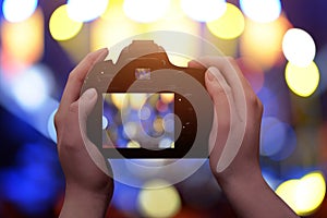 Profesional digital camera in hands. Blue and yellow bokeh in background