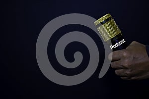 Profesional Microphone on hands isolated black background. Podcast Concept photo