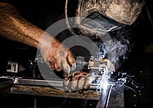 Profesional welder in protective mask welding metal and sparks metal