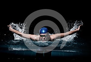 Profesional woman swimmer swim using breaststroke technique on the dark background