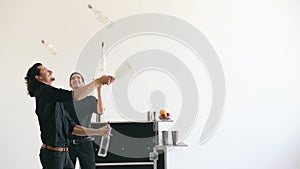 Professinal bartender men juggling bottles and shaking cocktail at mobile bar table on white background studio indoors photo