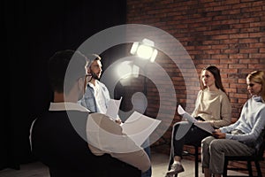 Professional actors reading their scripts during rehearsal in theatre