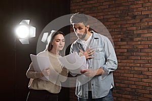 Professional actors reading their scripts during rehearsal in theatre