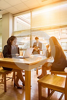 Professional administrative short black hair asian business woman hold book in hand and work with ladies co-worker in