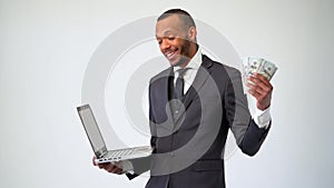 Professional african-american business man holding laptop computer and cash money