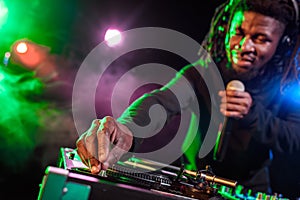professional african american club DJ in headphones with microphone