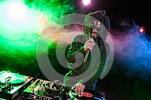 professional african american club DJ in headphones with mixer