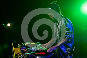 professional african american club DJ in headphones with sound mixer