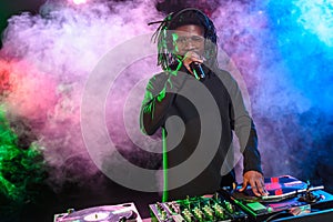 professional african american club DJ with sound mixer and microphone