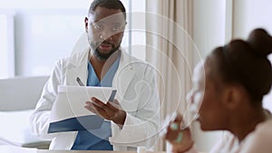 Professional african american doctor filling medical history of patient, blurred sick black woman coughing, free space