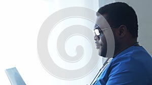 Professional african american medical doctor working in hospital office. Medicine and healthcare.