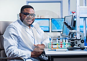 Professional African-American scientist is working on a vaccine in a modern scientific research laboratory. Genetic