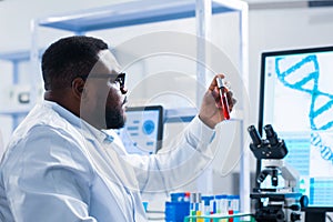 Professional African-American scientist is working on a vaccine in a modern scientific research laboratory. Genetic