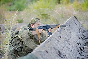 A professional airsoft player aims at his opponents.