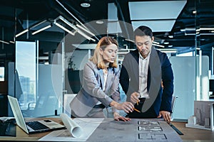 Professional architect designer structural engineer team colleagues working office looking computer screen discussing building