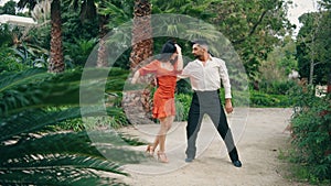 Professional artists dancing latin american dance in garden. Partners performing