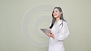 Professional Asian female doctor holding a tablet, looking away from camera