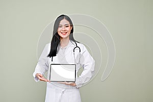 Professional Asian female doctor holding tablet mockup, standing against grey background