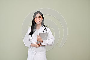 Professional Asian female doctor holding tablet, standing over isolated grey background