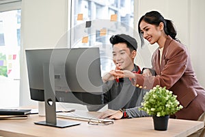 Professional Asian female manager training and giving advices to male web developer