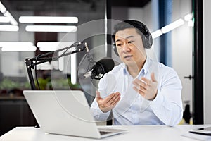 Professional asian male podcaster recording live show in studio