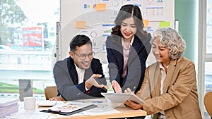 Professional Asian senior female boss in the meeting with her financial analysts team