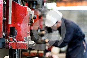 Professional asian worker stand and maintenance the big machine in the Warehouse factory. Concept Engineer Operating and control