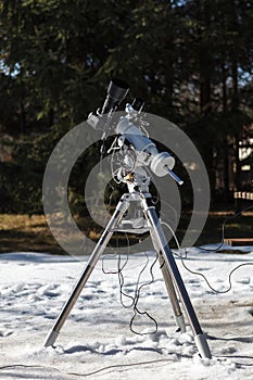 Professional astrophotography setup equipped with DSLR camera, telephoto lens and guider scope