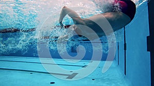 Professional athlete training in a swimming pool. Underwater shot. Concept of sports activity, determination, workout