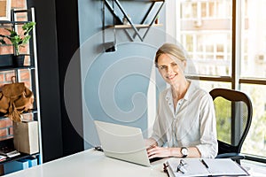 Professional attractive employee working in office cheerfully