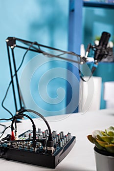 Professional audio mixer used for recording audio podcast on desk in empty vlog studio