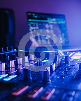 Professional audio mixing board connected to a laptop, displaying the various knobs and buttons.