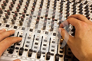 Professional audio mixing console with faders and adjusting knobs