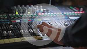 professional audio mixing console radio and TV broadcasting, sound producer hand is using faders