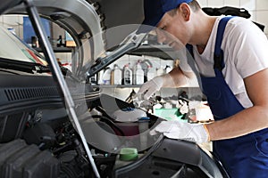 Professional auto mechanic fixing car in service center