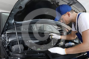 Professional auto mechanic fixing car in service center