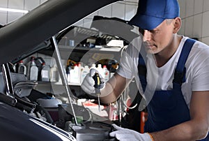 Professional auto mechanic fixing car in service center