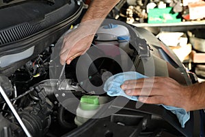 Professional auto mechanic fixing modern car in service center